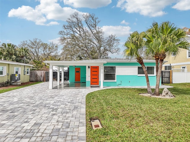 view of front of property with fence, decorative driveway, and a front yard