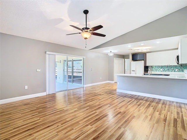 unfurnished living room featuring light hardwood / wood-style floors, lofted ceiling, ceiling fan, and sink