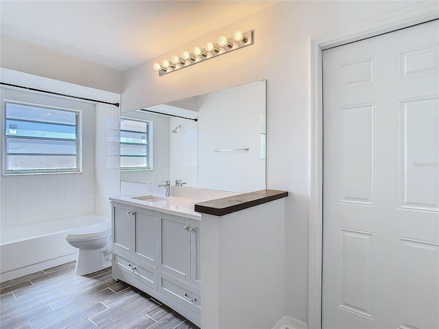 full bathroom with tiled shower / bath combo, vanity, and toilet