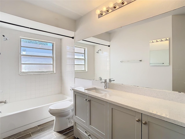 full bathroom with toilet, vanity, and tiled shower / bath