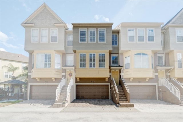 view of property with a garage, stucco siding, and stairs