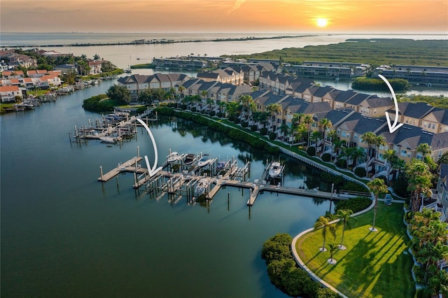 aerial view at dusk with a residential view and a water view