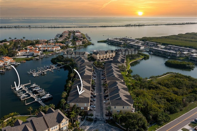 aerial view at dusk with a residential view and a water view