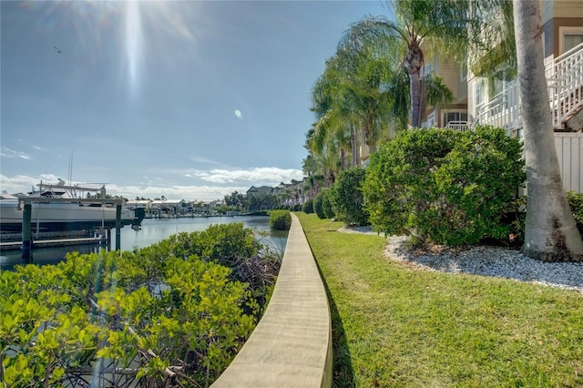 view of property's community with a yard, a water view, and boat lift