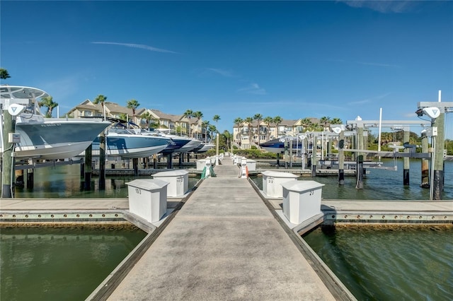 dock area featuring a residential view, boat lift, and a water view