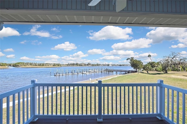 deck with a dock, a yard, and a water view