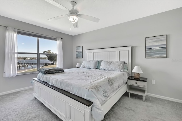 bedroom with a water view, ceiling fan, and carpet flooring