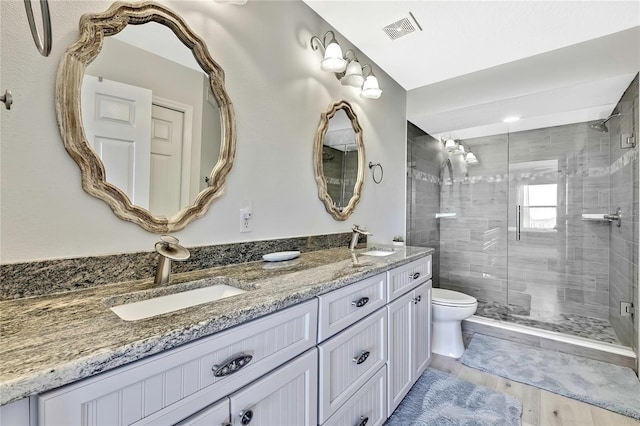 bathroom with toilet, vanity, an enclosed shower, and wood-type flooring