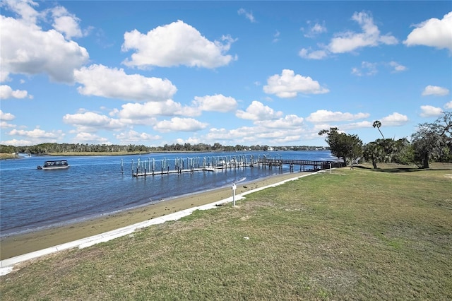 view of dock with a yard and a water view