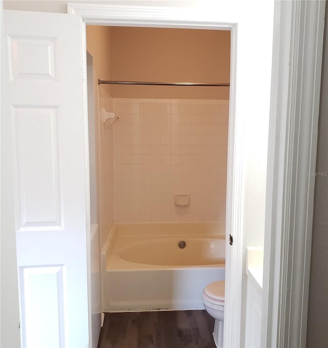 full bathroom featuring tiled shower / bath combo, wood-type flooring, vanity, and toilet