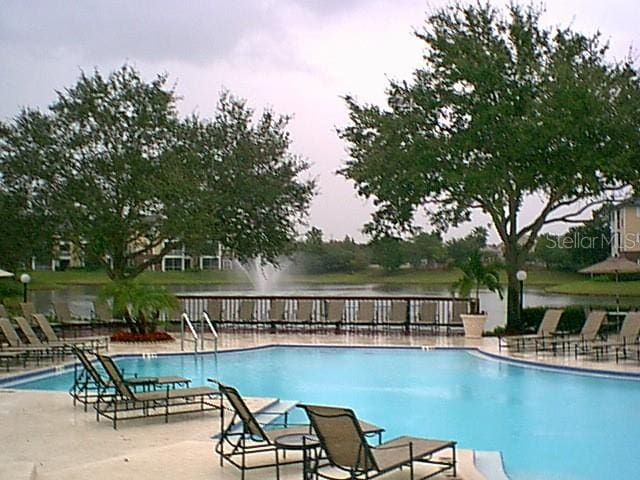 view of pool with a patio area and a water view