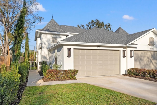 view of front facade with a garage, fence, driveway, roof with shingles, and stucco siding