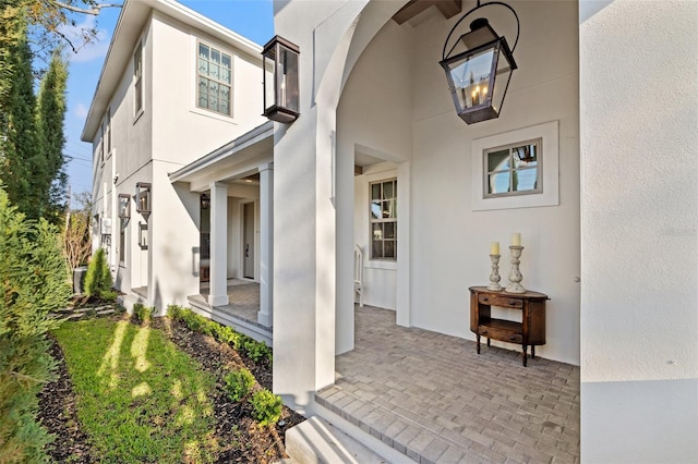 view of exterior entry featuring a patio area and stucco siding