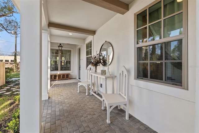 property entrance featuring covered porch and stucco siding