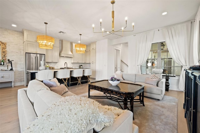 living area with light wood-type flooring, visible vents, a chandelier, and recessed lighting