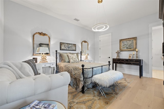 bedroom featuring light wood finished floors, baseboards, and visible vents