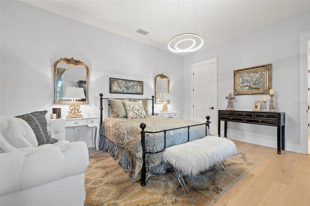 bedroom with light wood-type flooring, visible vents, and baseboards