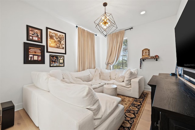 living area with a chandelier, recessed lighting, light wood-style flooring, and baseboards