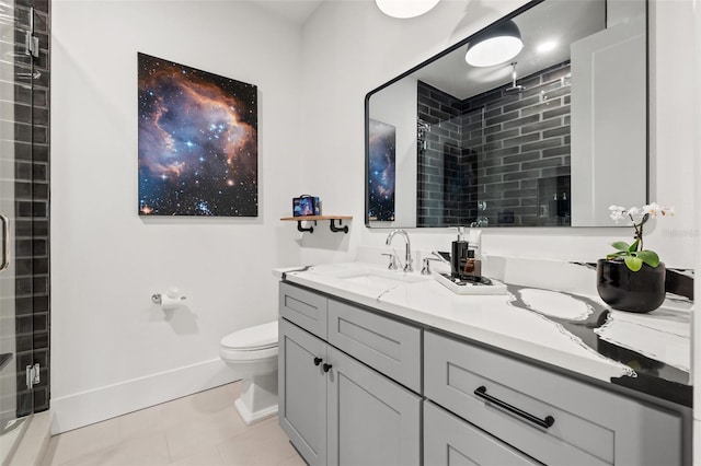 bathroom featuring toilet, a shower stall, vanity, tile patterned flooring, and baseboards