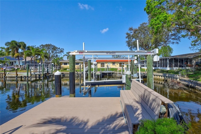 view of dock featuring a water view, boat lift, and a residential view