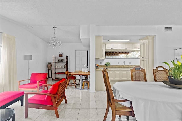 dining area with a notable chandelier, visible vents, a textured ceiling, and light tile patterned flooring