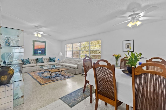 dining space featuring a ceiling fan, lofted ceiling, a textured ceiling, and speckled floor