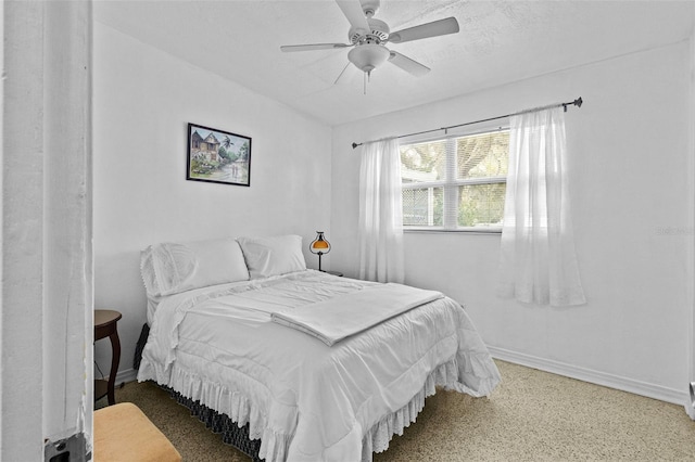 bedroom with ceiling fan, a textured ceiling, and baseboards