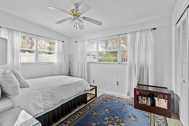 bedroom with a ceiling fan, a closet, and a textured ceiling