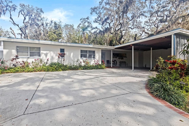 view of front facade featuring concrete driveway and a carport