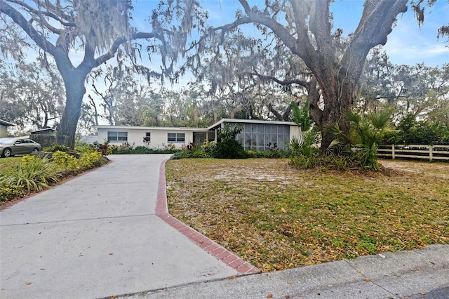 view of front of property featuring a sunroom and fence