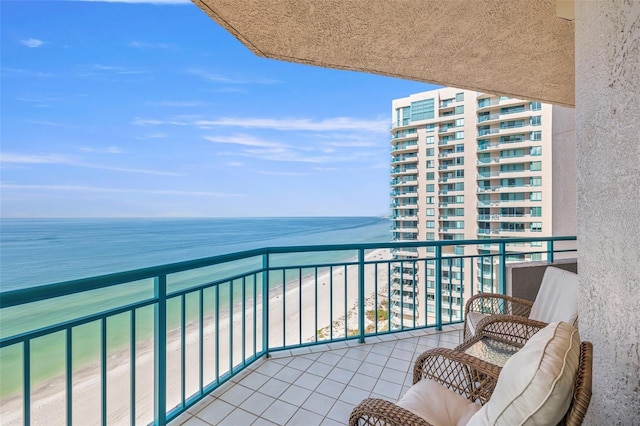 balcony featuring a water view and a beach view