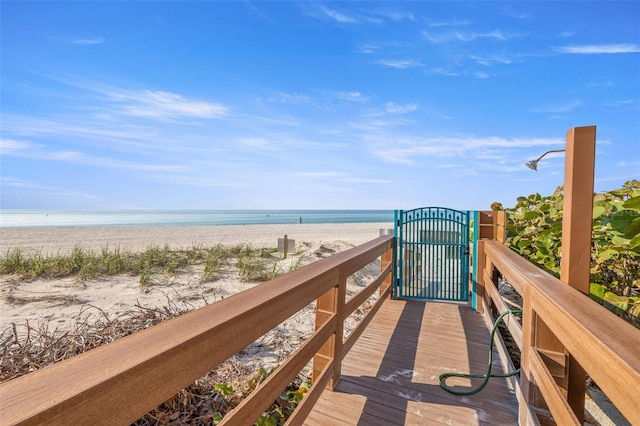 view of property's community featuring a water view and a beach view