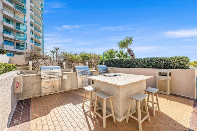 view of patio / terrace with exterior kitchen, an outdoor bar, and grilling area