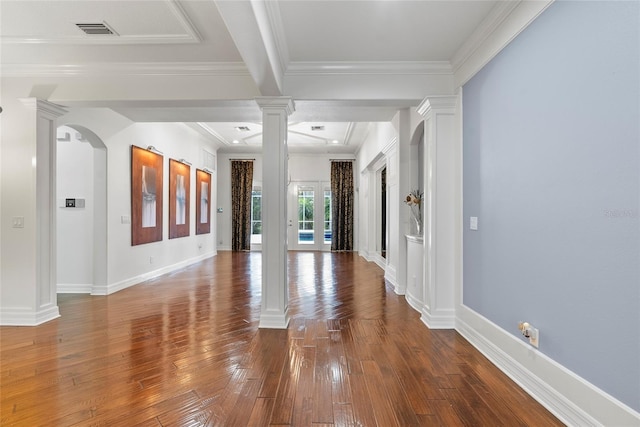 unfurnished room with arched walkways, hardwood / wood-style flooring, visible vents, ornamental molding, and decorative columns