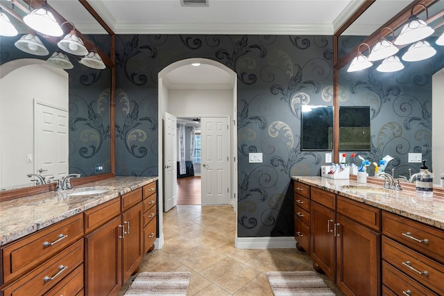 bathroom featuring wallpapered walls, two vanities, and a sink