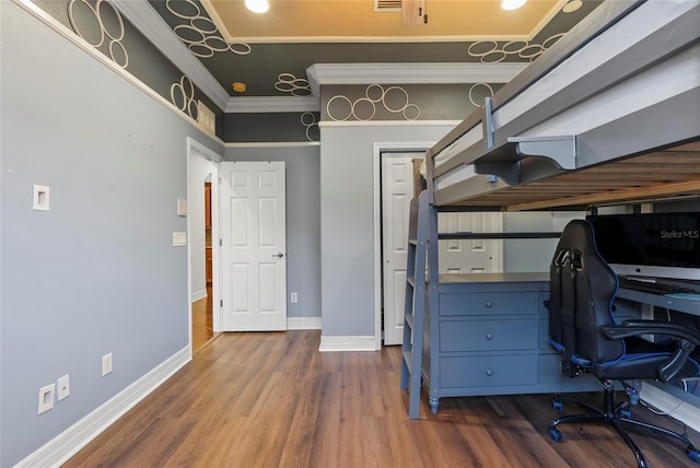 office space with ornamental molding, wood finished floors, and baseboards