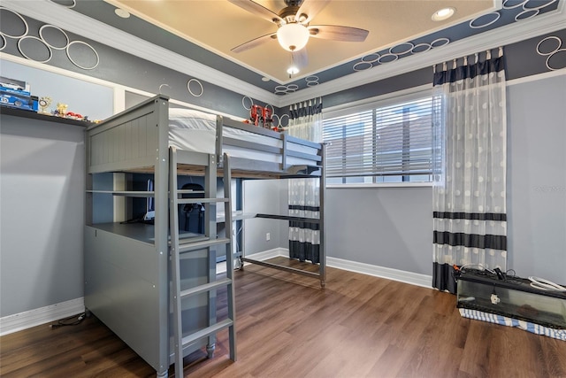 bedroom featuring crown molding, baseboards, and wood finished floors