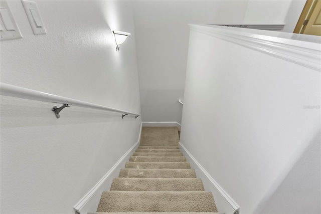 stairway featuring carpet and baseboards