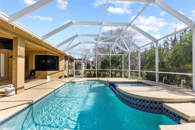 pool with a lanai, a patio area, and an in ground hot tub