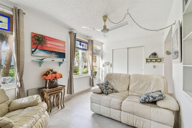 living room with a ceiling fan and a textured ceiling