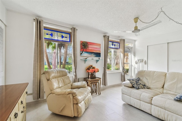 living area featuring ceiling fan and a textured ceiling