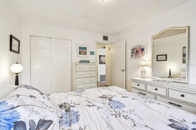 bedroom featuring a textured ceiling, a closet, and visible vents