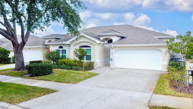 single story home featuring a garage, concrete driveway, a shingled roof, and stucco siding