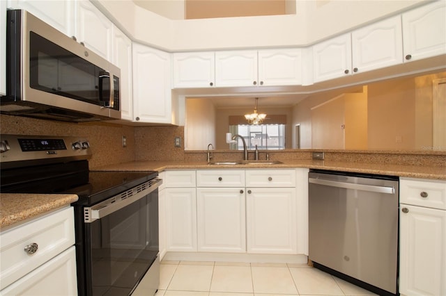 kitchen with stainless steel appliances, a sink, and white cabinetry