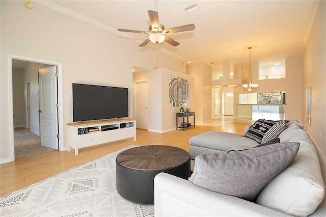 living room featuring baseboards, visible vents, wood finished floors, and ceiling fan with notable chandelier