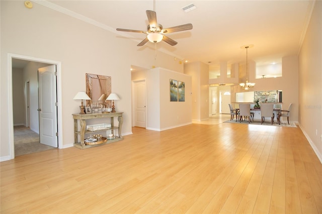 living room featuring visible vents, baseboards, light wood-style flooring, ornamental molding, and ceiling fan with notable chandelier