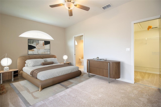 bedroom with connected bathroom, light carpet, a ceiling fan, visible vents, and baseboards