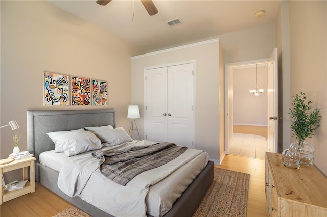 bedroom featuring ceiling fan, a closet, visible vents, and light wood-style floors