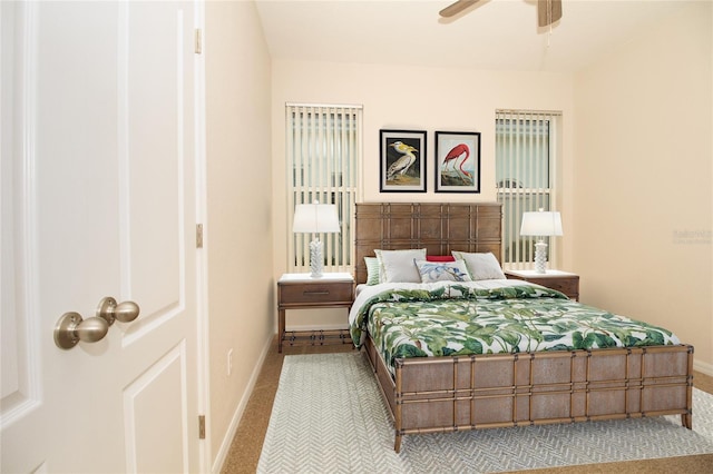 bedroom with light carpet, baseboards, and a ceiling fan