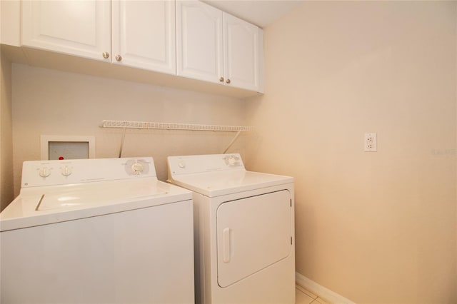 laundry area with cabinet space, washer and clothes dryer, baseboards, and light tile patterned flooring